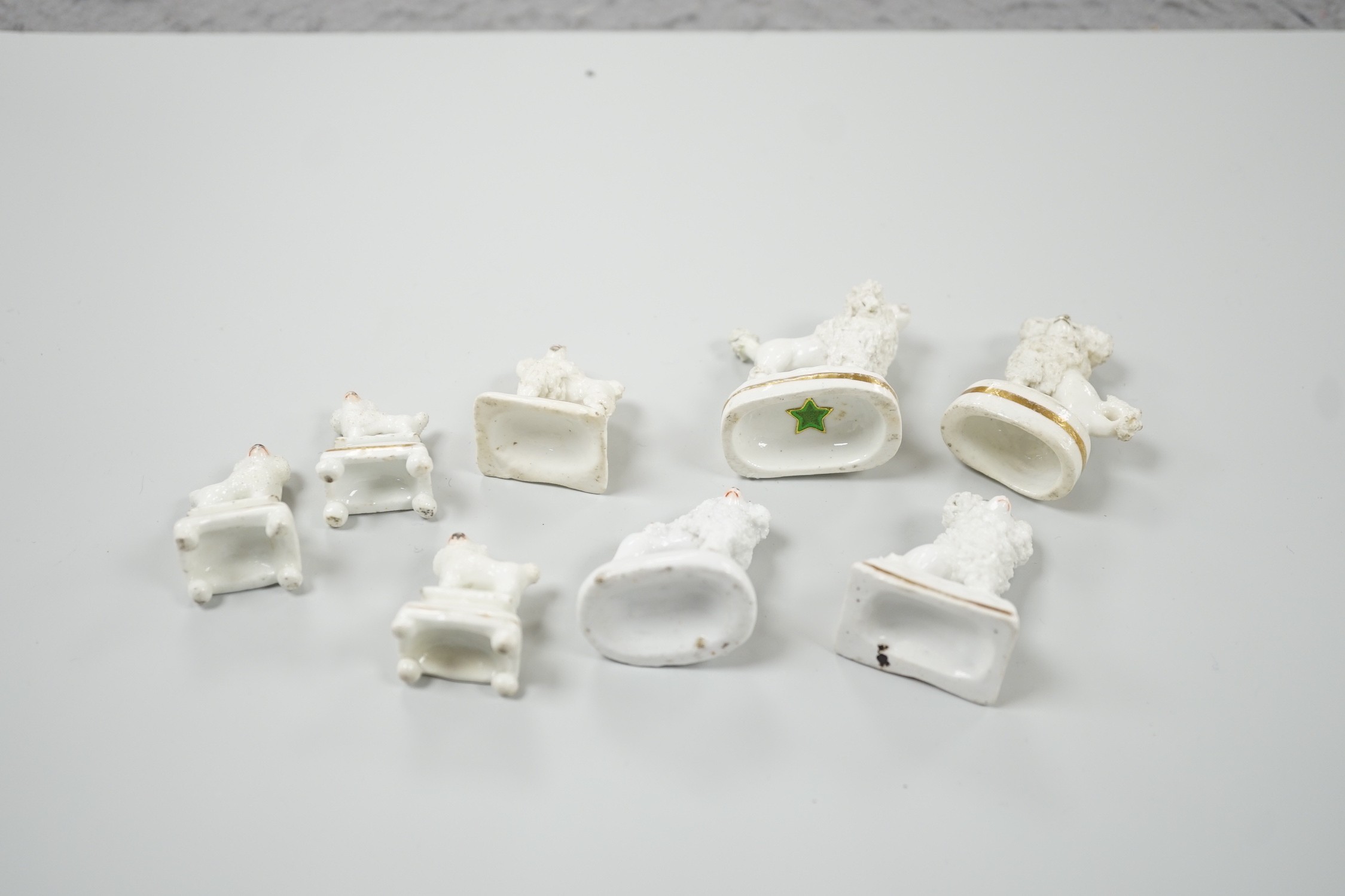 Four small Staffordshire porcelain models of poodles, together with five toy Staffordshire models of poodles, c.1830-50. Largest 5cm tall, Provenance- Dennis G Rice collection